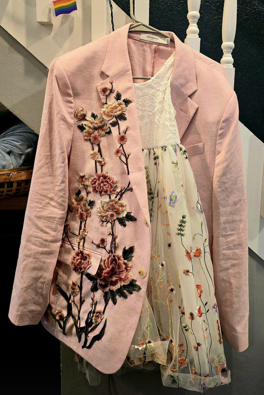 Stunning custom clothing DIY showcasing a large 3D floral embroidery flower patch seamlessly applied to the front of a light pink blazer jacket, paired with a floral lace dress for a couture fashion aesthetic.