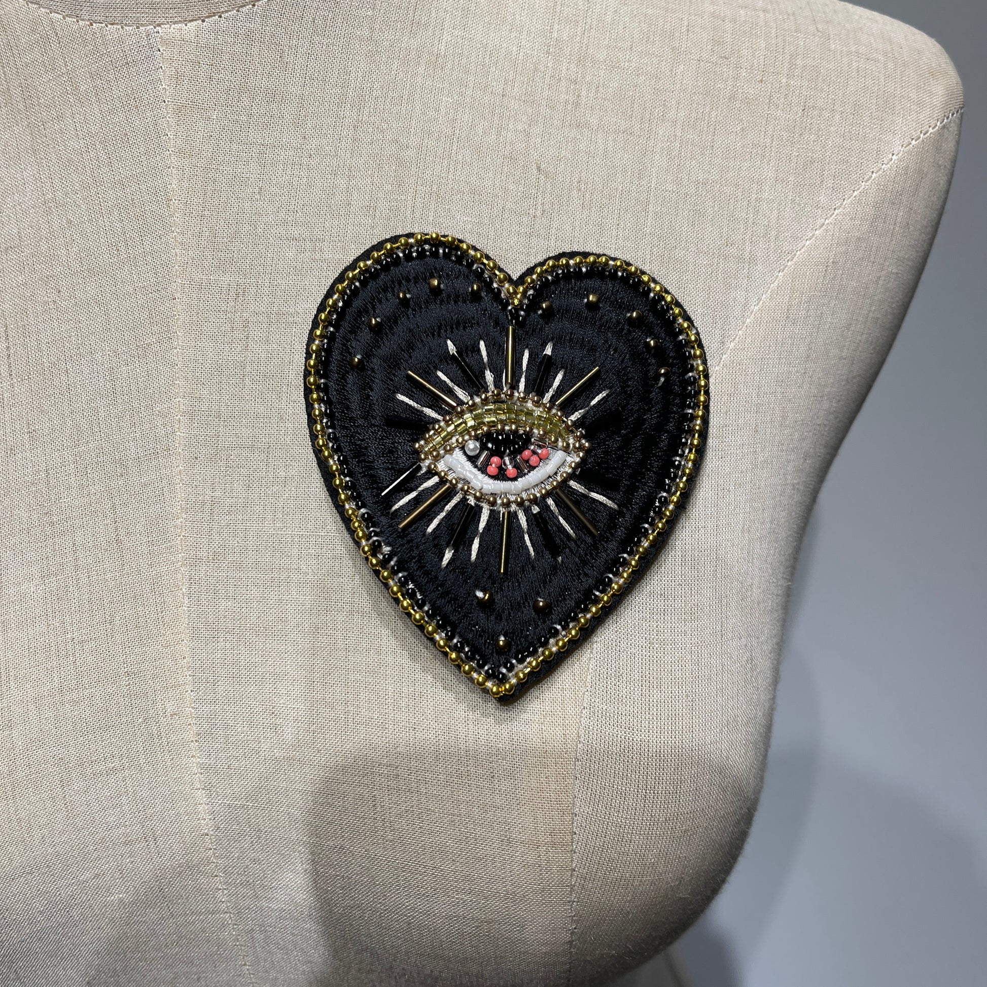 ⁠Mannequin chest displaying a custom luxury handmade black evil eye beaded heart patch - 9x8.5cm.⁠
