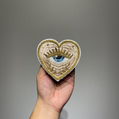 ⁠Handmade 10cm evil eye beaded heart patch featuring gold metallic embroidery, faux pearls, and glass seed beads for DIY fashion and jacket repair.⁠