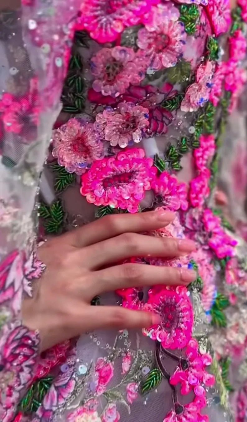 Exquisite application of the beaded floral patch on a luxury couture gown, showcasing close-up hand-beaded details with pink sequins and glass bugles on a sheer lace sleeve.⁠