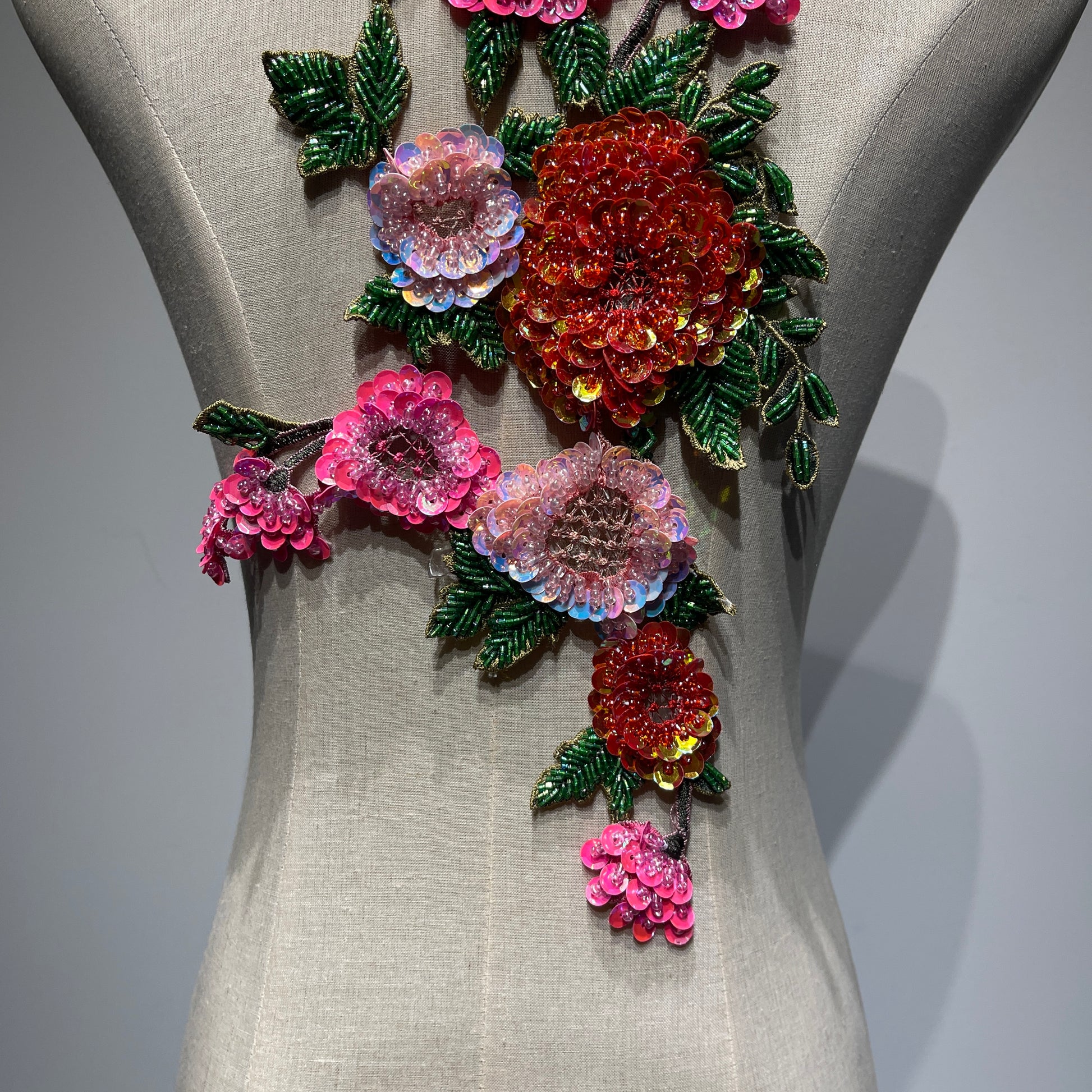⁠A medium close-up of the lower half of the beaded floral patch, highlighting the dense metallic sequins, intricate glass bugle beadwork, and layered hand-stitched petals.⁠