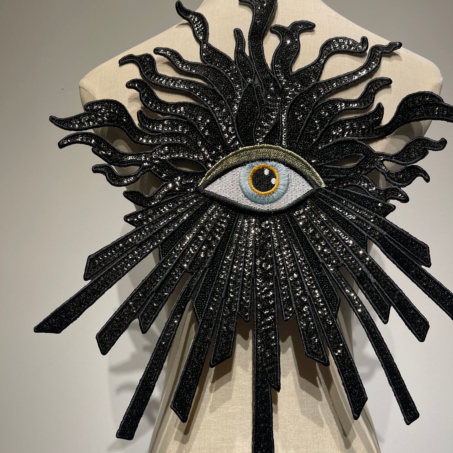 Close-up detail of handcrafted luxury evil eye patch, showcasing high-shine black sequins, premium embroidery beads, and intricate needlework.