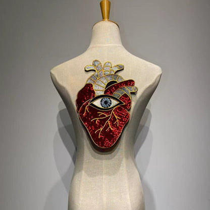 Oversized anatomical heart and evil eye sequin back patch on a mannequin denim jacket back.⁠