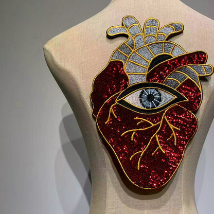 ⁠Front view of an oversized anatomical heart and evil eye sequin back patch displayed on a mannequin