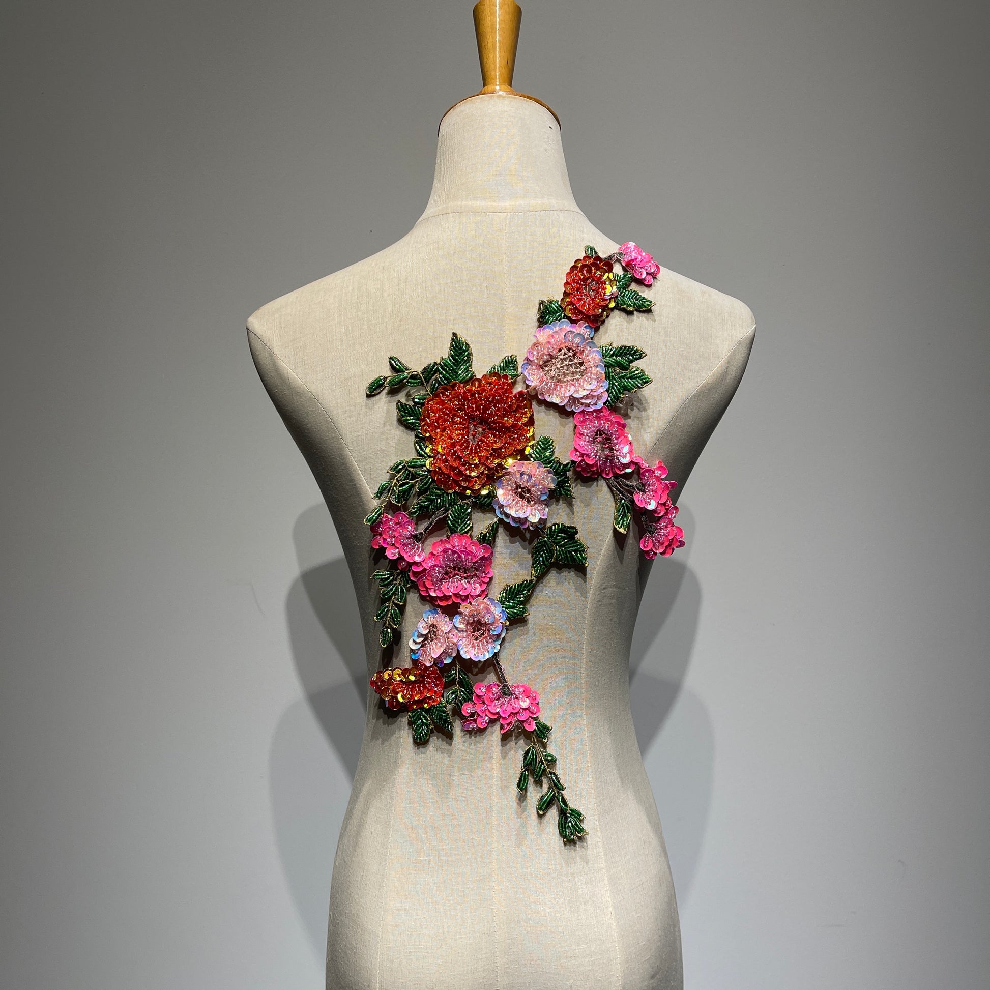⁠The 39.5cm beaded floral couture patch styled in a reversed direction on a mannequin, demonstrating its versatility for different creative clothing layouts.⁠