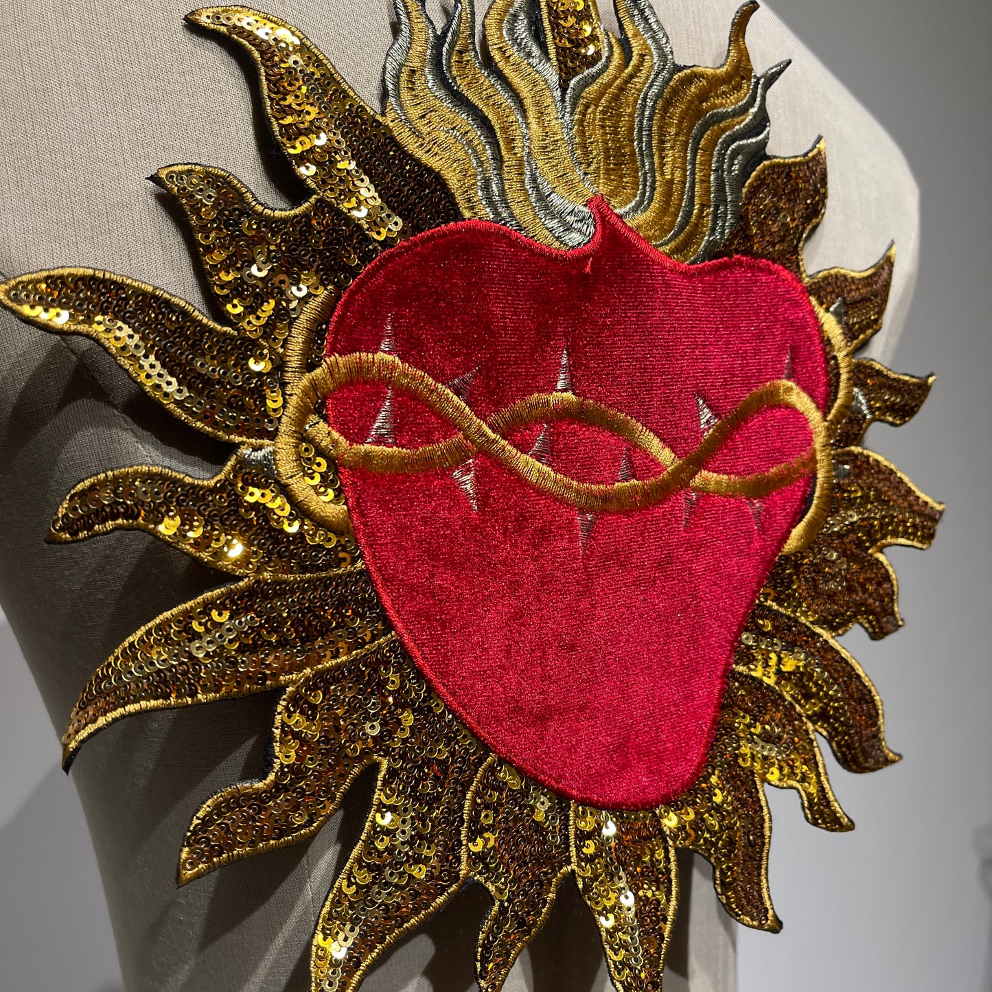 Side angle showing 3D tactile dimension of gold sequin beams and premium red velvet on sacred heart back patch patchmanstore