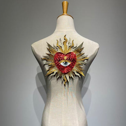 Luxury red sacred heart sequin patch on a mannequin, handcrafted medium-large flaming sunburst and evil eye embroidery patch for jacket DIY custom fashion.