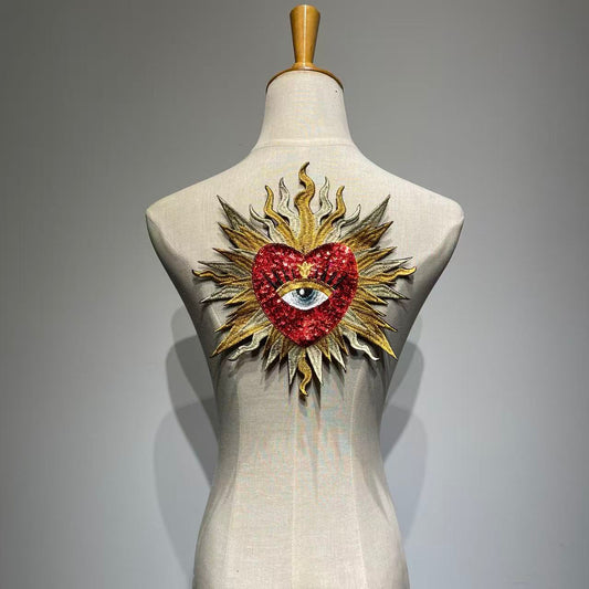 Luxury red sacred heart sequin patch on a mannequin, handcrafted medium-large flaming sunburst and evil eye embroidery patch for jacket DIY custom fashion.
